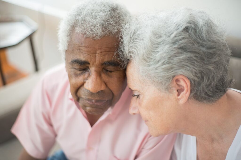 A close-up of a senior couple sharing a tender and emotional moment together.